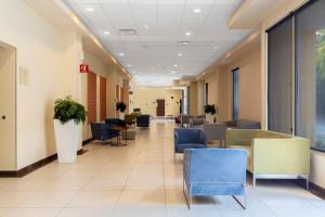 a waiting room in a hospital with chairs and tables at City Express by Marriott Playa del Carmen in Playa del Carmen +87 photos