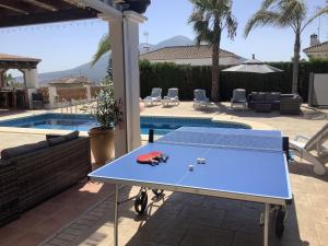 una mesa de ping pong azul frente a una piscina en Casa Sierra - 4 bedroom villa with pool - Alhaurin el Grande, Coin, Mijas Pueblo, en Coín