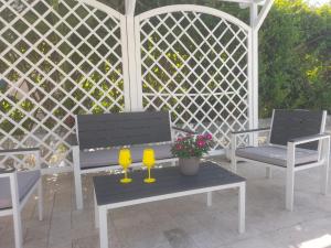 dos copas de vino amarillas sentadas en una mesa en un patio en Villa Eufrosine, en Palermo