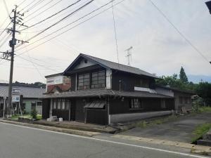 an old house on the side of a street at Momiji hostel in Minami Aso