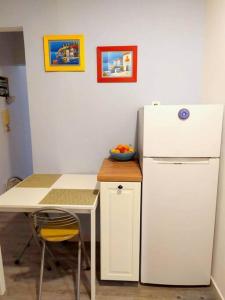 a kitchen with a white refrigerator and a table at KORA Piraiki in Piraeus