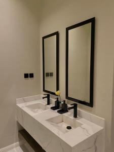 a bathroom with two sinks and two mirrors at STAY Villa in Riyadh