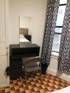 a piano in a room with a mirror and a chair at 1C CLOSe in New York