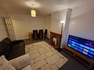 a living room with a couch and a flat screen tv at Millmead Apartment in central Guildford with parking in Guildford