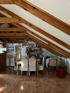 a dining room with a table and white chairs at The Cozy Attic Stay in Herceg-Novi