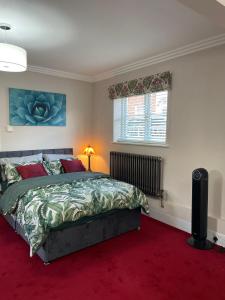 Schlafzimmer mit einem Bett und einem roten Teppich in der Unterkunft Luxurious and Elegant Homestay in Kent in Wrotham