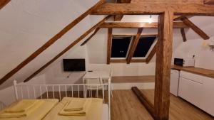 a room with a bed and a kitchen with wooden beams at Apartments Žnidar in Bohinj