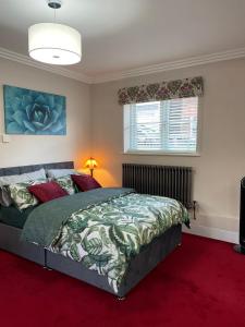 Schlafzimmer mit einem Bett und einem roten Teppich in der Unterkunft Luxurious and Elegant Homestay in Kent in Wrotham