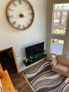 a living room with a large clock on the wall at RidgeWalk Main House in Angel Fire