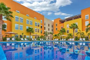 a large swimming pool in front of a building at City Express Plus by Marriott Cabo San Lucas in Cabo San Lucas