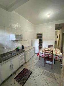 a kitchen with a table and a refrigerator in it at Apartamento para 8 pessoas próximo a Basílica in Aparecida