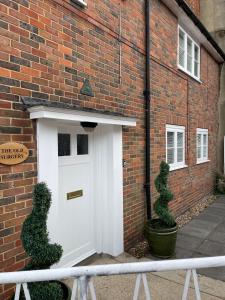 a white door on the side of a brick building at Luxurious and Elegant Homestay in Kent in Wrotham