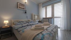 een slaapkamer met een groot bed en handdoeken bij Apartament w Centrum in Sandomierz