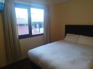 ein Schlafzimmer mit einem weißen Bett und einem Fenster in der Unterkunft Hotel RustiCall in La Paz