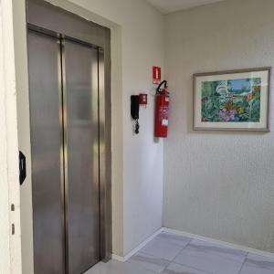 a fire extinguisher on a wall next to a door at Apartamento Dei Fiori in Guaramiranga