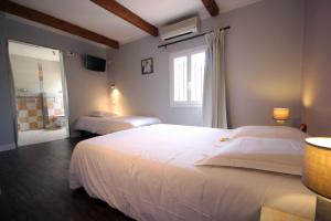 a bedroom with two white beds and a window at Ô Villagio Hôtel in Villeneuve-Loubet