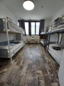 a room with three bunk beds and a wooden floor at Atmos Luxe Navigli in Milan