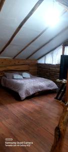een slaapkamer met een bed in een houten kamer bij Cabaña en la Calera el refugio campestre in La Calera