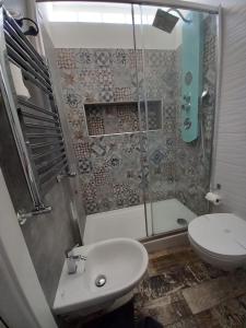 y baño con ducha, aseo y lavamanos. en Atmos Luxe Navigli, en Milán