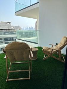 two chairs on a balcony with a view of the city at Luxury 2 bedrooms 5 minutes from Burj Khalifa in Dubai