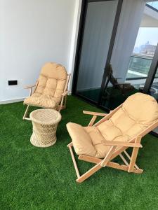 two chairs and a table in a room with green grass at Luxury 2 bedrooms 5 minutes from Burj Khalifa in Dubai