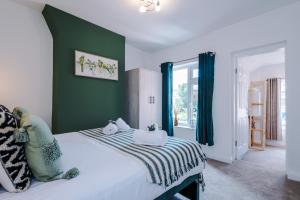 um quarto com uma cama com uma parede verde em Spacious 3-bed home in Nantwich by 53 Degrees Property - Amazing location, Ideal for Groups - Sleeps 6 em Nantwich