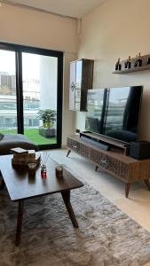 a living room with a large television and a table at Luxury 2 bedrooms 5 minutes from Burj Khalifa in Dubai