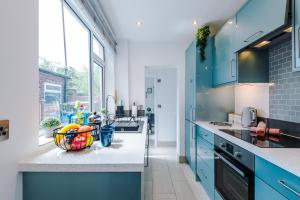 a kitchen with blue cabinets and a counter top at Spacious 3-bed home in Nantwich by 53 Degrees Property - Amazing location, Ideal for Groups - Sleeps 6 in Nantwich