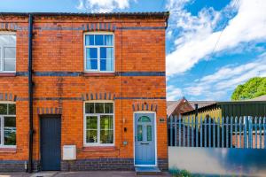 a red brick house with a blue door at Spacious 3-bed home in Nantwich by 53 Degrees Property - Amazing location, Ideal for Groups - Sleeps 6 in Nantwich