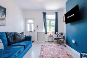 a blue couch in a living room with a blue wall at Spacious 3-bed home in Nantwich by 53 Degrees Property - Amazing location, Ideal for Groups - Sleeps 6 in Nantwich
