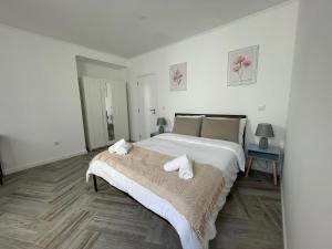 a white bedroom with a large bed with towels on it at Charming Benavente in Benavente