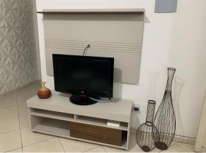 TV de pantalla plana en la parte superior de un armario blanco en Apartamento confortável com espaço exclusivo, en Cachoeira Paulista