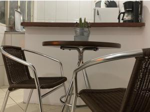 una mesa con dos sillas y una maceta en ella en Apartamento confortável com espaço exclusivo, en Cachoeira Paulista