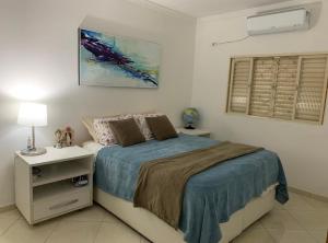 1 dormitorio con 1 cama con mesita de noche y ventana en Apartamento confortável com espaço exclusivo, en Cachoeira Paulista