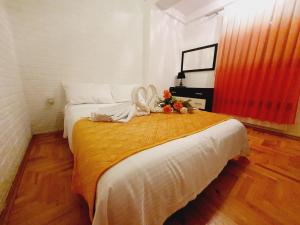 um quarto com uma cama com um cobertor laranja em Family Apartment em Kumanovo