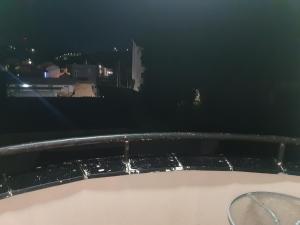 uma banheira na varanda à noite em Family Apartment em Kumanovo