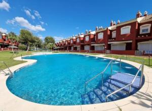 a large swimming pool in front of a building at Apartamento Islantilla Club in Islantilla