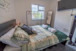 een slaapkamer met een bed met kussens erop bij Entire home in Nottingham in Nottingham