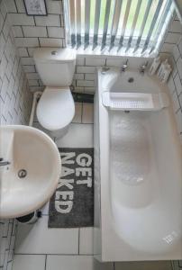 een witte badkamer met een wastafel en een toilet bij Entire home in Nottingham in Nottingham