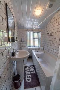 een badkamer met een wastafel, een bad, een wastafel en een toilet bij Entire home in Nottingham in Nottingham