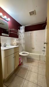 a bathroom with a toilet and a sink and a tub at B'more Inn Motel in Baltimore