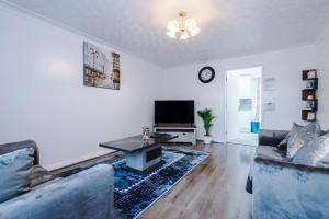 a living room with two couches and a tv at Cozy Home Away From Home in Manchester. in Manchester