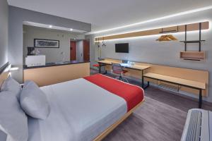 a hotel room with a bed and a desk at City Express by Marriott Irapuato in Irapuato