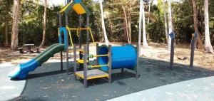 um parque infantil com escorrega num parque em Cosy Studio em Port Douglas