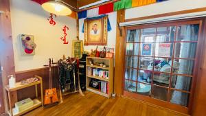una stanza con libreria e porta di ペンションminiモンゴル a Makito
