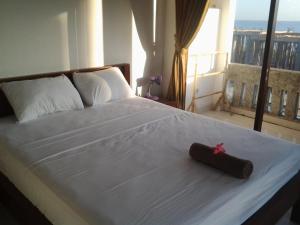 a bedroom with a bed with a red ribbon on it at Sony Home Stay in Amed