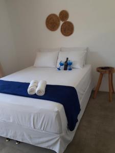 a bedroom with a white bed with towels on it at Marinho Suítes Milagres in São Miguel dos Milagres