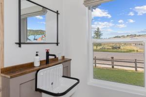 La salle de bains est pourvue d'un lavabo et d'une fenêtre. dans l'établissement Hotel Palomino, à Ridgway