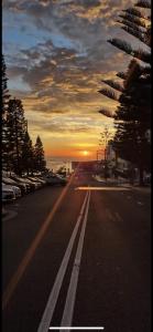 an empty street with a sunset in the background at Ocean view in Sydney