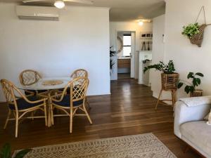 uma sala de estar com uma mesa e cadeiras e um sofá em Kalua Holiday Apartments em Maroochydore